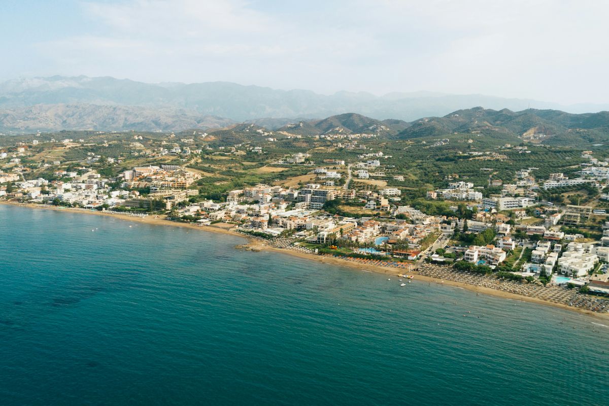 The long sandy coastline of Agia Marina with the White Mountains behind