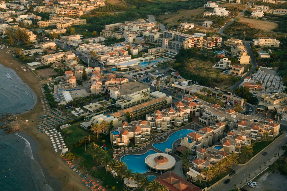 Golden hour over Agia Marina's beach, pools and umbrellas